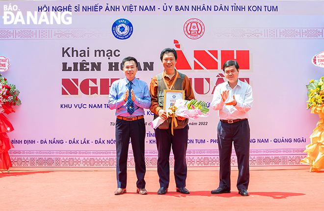 The festival's organisers awarding the Gold Medal to photographer Huynh Van Truyen from Da Nang at the opening ceremony of the exhibition. 