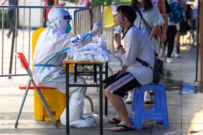 Nhân viên y tế lấy mẫu xét nghiệm Covid-19 cho người dân tại Quảng Châu, Trung Quốc ngày 31/7/2022. Ảnh: TTXVN