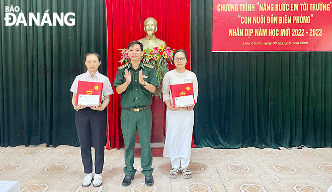 Thượng tá Đinh Ngọc Anh (giữa), Phó Chủ nhiệm Chính trị Bộ đội Biên phòng thành phố trao quà cho học sinh có hoàn cảnh khó khăn trên địa bàn quận Liên Chiểu. Ảnh: PHƯƠNG MINH