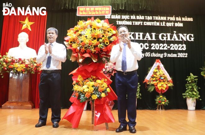Bí thư Thành ủy Nguyễn Văn Quảng tặng hoa chúc mừng năm học mới. Ảnh: NGỌC HÀ