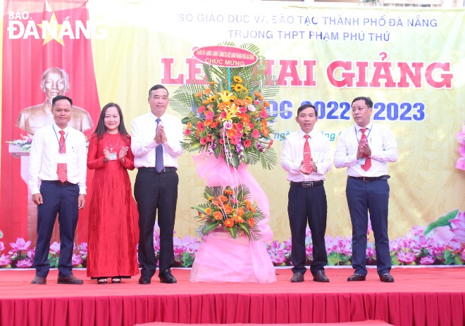 Chủ tịch UBND thành phố Lê Trung Chinh (thứ 3, từ trái sang) tặng hoa chúc mừng lễ khai giảng năm học mới tại Trường THPT Phạm Phú Thứ. Ảnh: NGỌC QUỐC