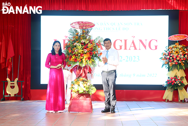 Municipal People's Committee Vice Chairman Ho Ky Minh (right) presenting congratulatory flowers at the opening ceremony of a new academic year at the Le Do Secondary School in Son Tra District. Photo: XUAN DUNG