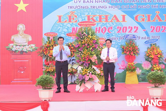 Municipal People's Committee Vice Chairman Tran Phuoc Son (left) congratulating the Ngo Thi Nham Secondary School on the occasion of the new school year. Photo: PHI NONG