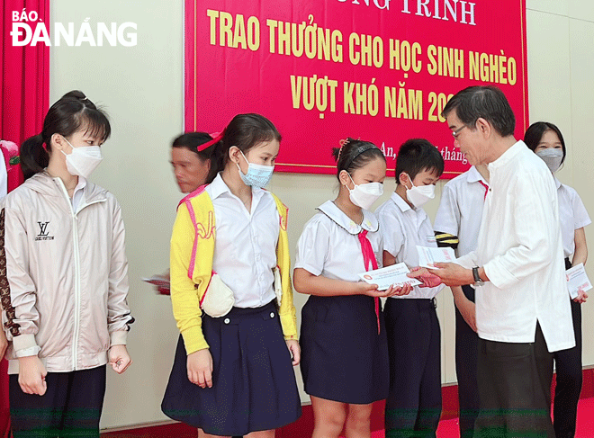 Chủ tịch Hội Khuyến học quận Cẩm Lệ Trần Văn Phi trao thưởng học sinh nghèo vượt khó ở phường Hòa An năm 2022. Ảnh: LÊ VĂN THƠM