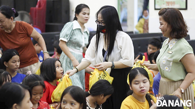 Những phần quà được chị Lê Phương Thảo, Phó Giám đốc trung tâm nuôi dạy trẻ em khó khăn thành phố Đà Nẵng (bên tay phải) và các nhà hảo tâm gửi tới các em nhỏ.