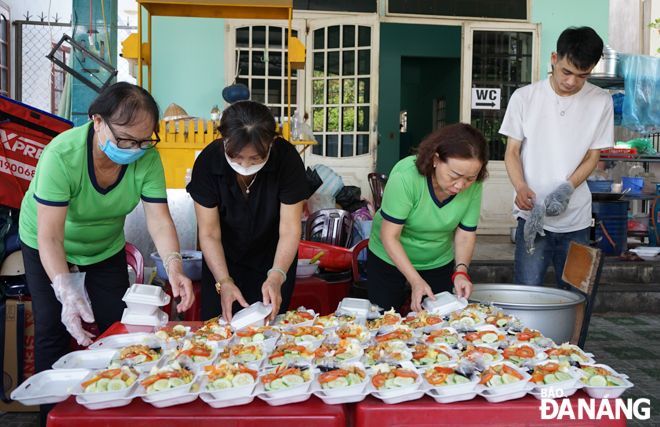 Every Tuesday noon, an average of 100 portions of lunch meals and drinks are given to needy people. Photo: TRUONG KY