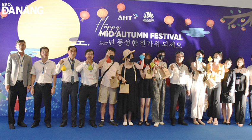 Deputy Director of the Da Nang Tourism Department Tan Van Vuong (fourth, left) and representatives of the Da Nang International Terminal Investment and Exploitation Joint Stock Company presenting gifts to South Korean tourists before the flight time. Photo: THU HA