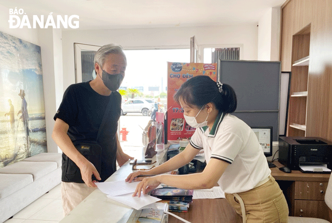 Ms Le Thi Ai Chung (right), a staff member from the Visitor Center located at 108 Bach Dang providing information to a foreign tourist. Photo: THU HA