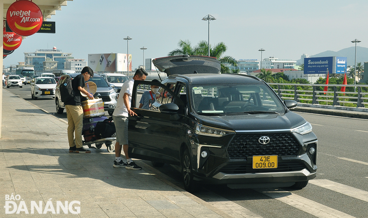 Hành khách đi taxi ở Sân bay Đà Nẵng. Ảnh: PHƯƠNG UYÊN