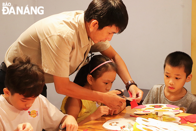 Staff of the Da Nang Fine Arts Museum instructing children to make traditional lanterns.