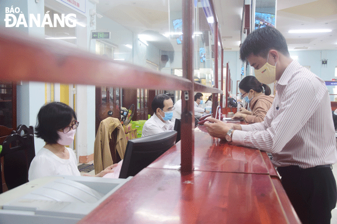 Người dân giao dịch tại bộ phận “Một cửa” Trung tâm Hành chính quận Thanh Khê. Ảnh: TRỌNG HUY