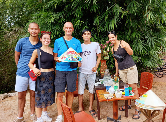 Mr. Phan Cong Nhat (second, right) takes a souvenir photo with a family from Belgium (Photo courtesy of the character)