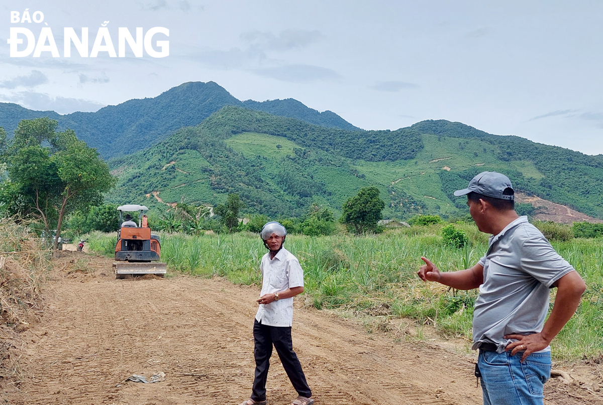 Phó Bí thư Chi bộ kiêm Trưởng thôn Phò Nam (xã Hòa Bắc) Nguyễn Sinh (bên trái) cùng người dân hiến đất tiến hành kiểm tra việc thi công tuyến đường nội đồng ở thôn Phò Nam. Ảnh: TRỌNG HÙNG