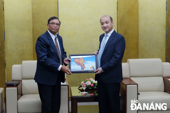 Phó Chủ tịch UBND thành phố Lê Quang Nam (bên phải) tặng quà lưu niệm cho Phó tỉnh trưởng Sê Kông Khamsone Konnho. Ảnh: N.V