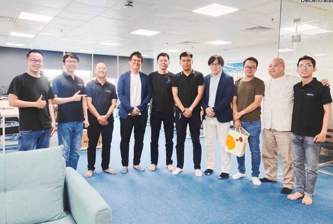 Mr. Le Thanh Tung (second) and colleagues from Japan discuss blockchain. (Photo courtesy of the character)