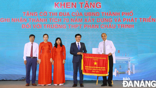 Da Nang People's Committee Vice Chairman Le Quang Nam (right, first) presenting the emulation flag of the municipal People's Committee to the school. Photo: NGOC HA