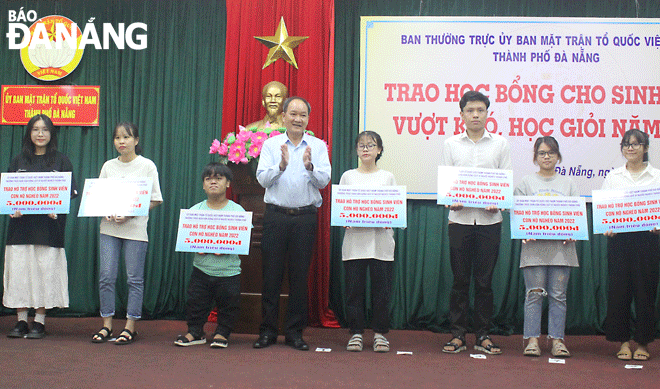 Phó Chủ tịch Ủy ban MTTQ Việt Nam thành phố Dương Đình Liễu trao học bổng cho sinh viên con hộ nghèo vượt khó học giỏi năm học 2021-2022. Ảnh: X.HẬU