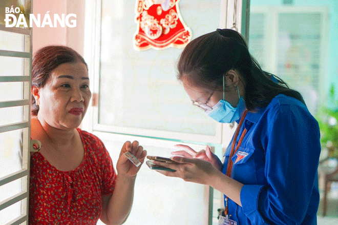 The city is gradually building a model of digital government and digital citizenship, bringing many benefits to locals and businesses. IN THE PHOTO: A Youth Union member in Son Tra District (right) instructing a resident to use electronic public services. Photo: QUYNH TRANG