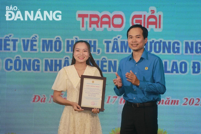 Chairman of the Da Nang Labour Confederation Nguyen Duy Minh awarding the first prize to reporter Tran Thi Kim Phuong from the Da Nang Newspaper. Photo: X.HAU