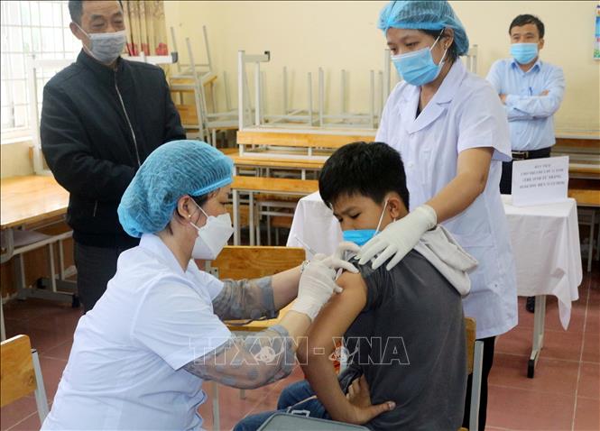 Các trẻ tại điểm tiêm trường THCS Lương Khánh Thiện (thành phố Phủ Lý, tỉnh Hà Nam) dưới sự theo dõi của phụ huynh và nhân viên y tế. Ảnh tư liệu: Đại Nghĩa/TTXVN