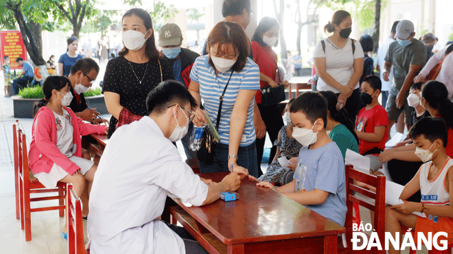 Thành phố tiếp tục đẩy mạnh tiêm vắc-xin phòng Covid-19 cho các nhóm đối tượng.  TRONG ẢNH: Nhân viên y tế làm thủ tục tiêm vắc-xin cho học sinh tại điểm tiêm Trường THCS Tây Sơn, quận Hải Châu. Ảnh: PHAN CHUNG