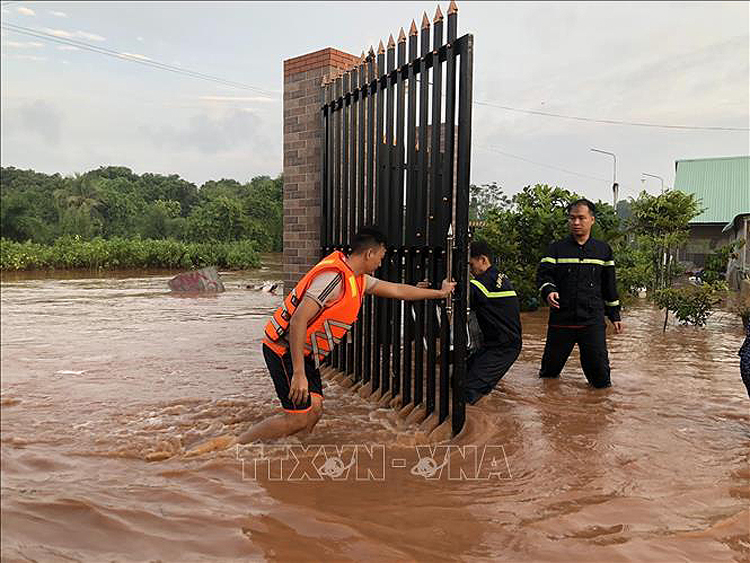 Lực lượng chức năng hỗ trợ người dân xã Thanh Lương (thị xã Bình Long, tỉnh Bình Phước) khắc phục hậu quả do mưa lũ gây ra ngày 22/9. Ảnh: TTXVN phát.