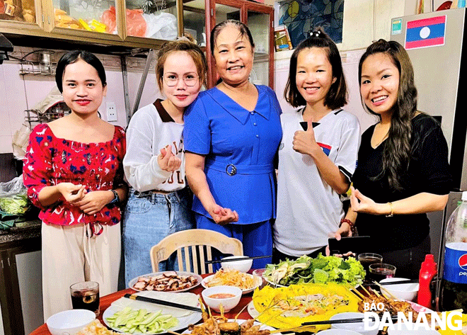 Bà Trần Thị Nguyện (giữa) và các sinh viên Lào thường xuyên sum họp, nấu các món truyền thống của hai đất nước. Ảnh: H.H