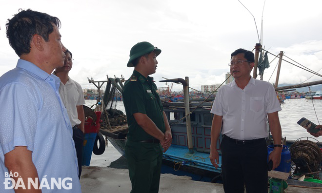 Phó Chủ tịch UBND Trần Phước Sơn (bìa phải) chỉ đạo các đơn vị tích cực hướng dẫn, sắp xếp tàu thuyền neo đậu trú bão an toàn trong âu thuyền Thọ Quang. Ảnh: HOÀNG HIỆP