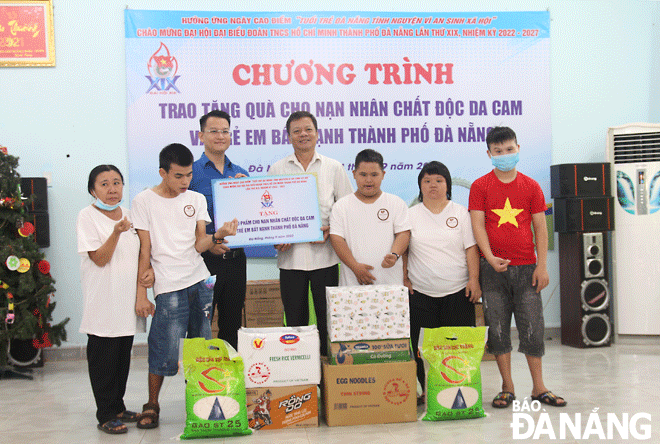 Bí thư Thành Đoàn Nguyễn Mạnh Dũng (thứ 3, bên trái sang) trao quà cho các em thiếu nhi tại Trung tâm Bảo trợ nạn nhân chất độc da cam và trẻ em bất hạnh thành phố.  Ảnh: NGỌC QUỐC	