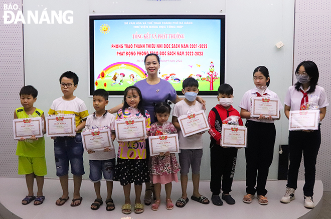 A representative from the Da Nang General Science Library presenting gifts to primary school pupils in recognition of their outstanding reading achievements in the 2021-2022 academic year. Photo: THIEN DUYEN