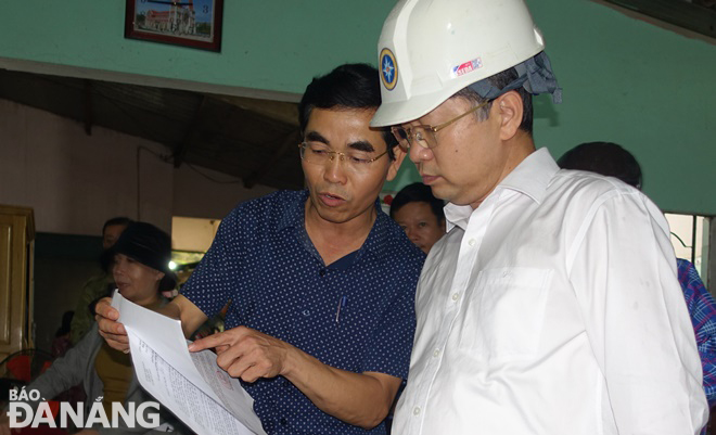 Secretary Quang (right) examining documents related to handling landslides in Hoa Vang District.