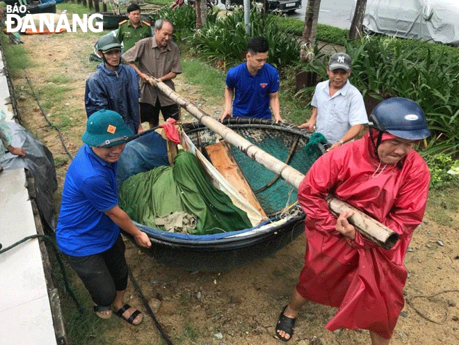 Tuổi trẻ quận Thanh Khê ra quân hỗ trợ ngư dân đưa thúng vào nơi tránh trú bão an toàn. Ảnh: NGỌC QUỐC