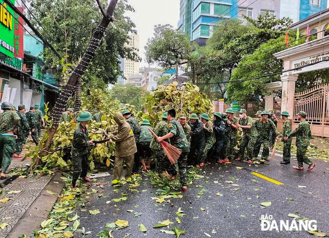 Giúp dân dọn cây sau bão.