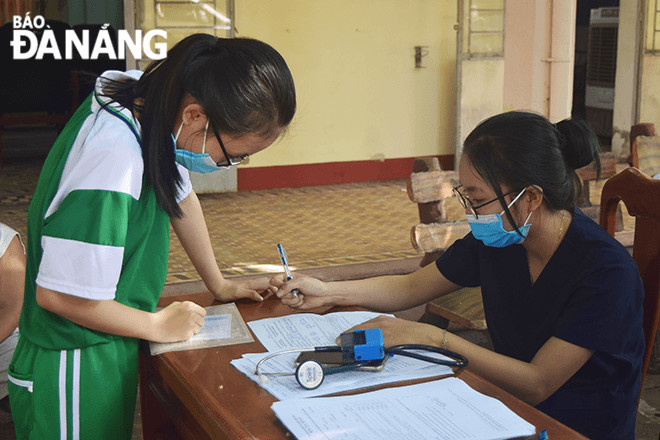 Sau khi học xong, học sinh Trường THCS Nguyễn Lương Bằng tham gia tiêm vắc-xin phòng Covid-19 tại điểm tiêm lưu động được đặt tại trường. Ảnh: THU DUYÊN