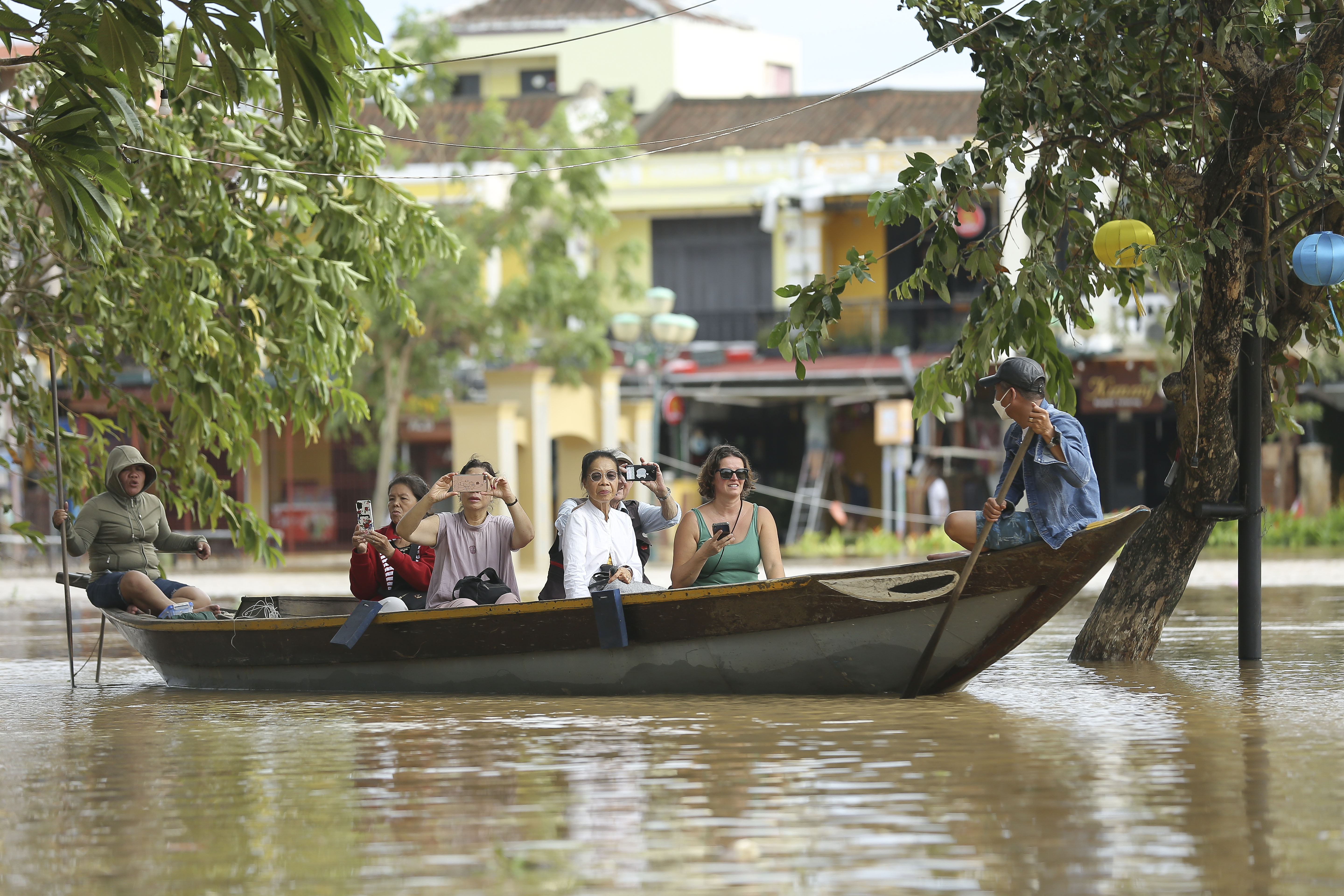 Tourists rent a boat to ride around flooded streets
