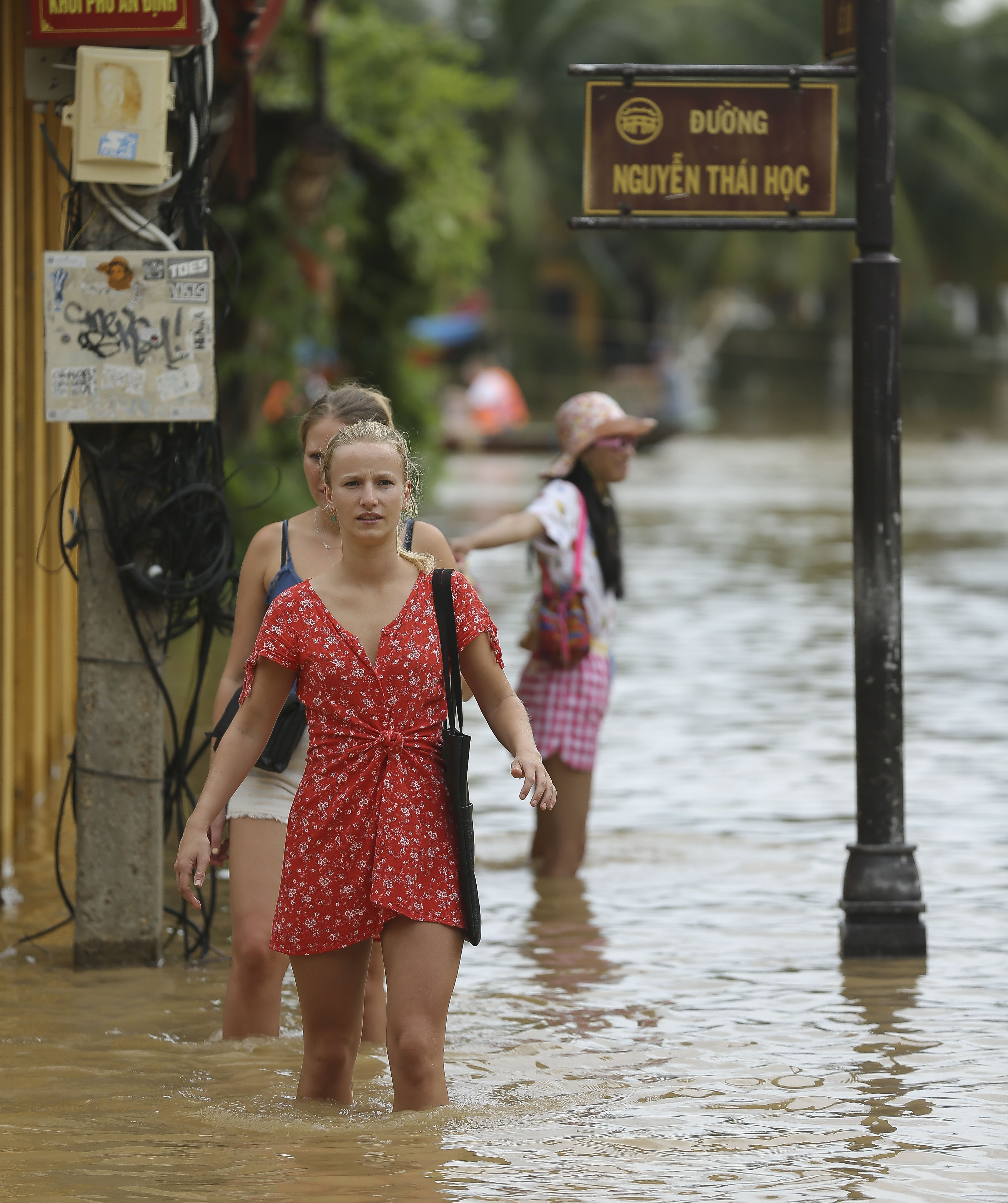 Many foreign tourists are very excited at wading in floodwaters