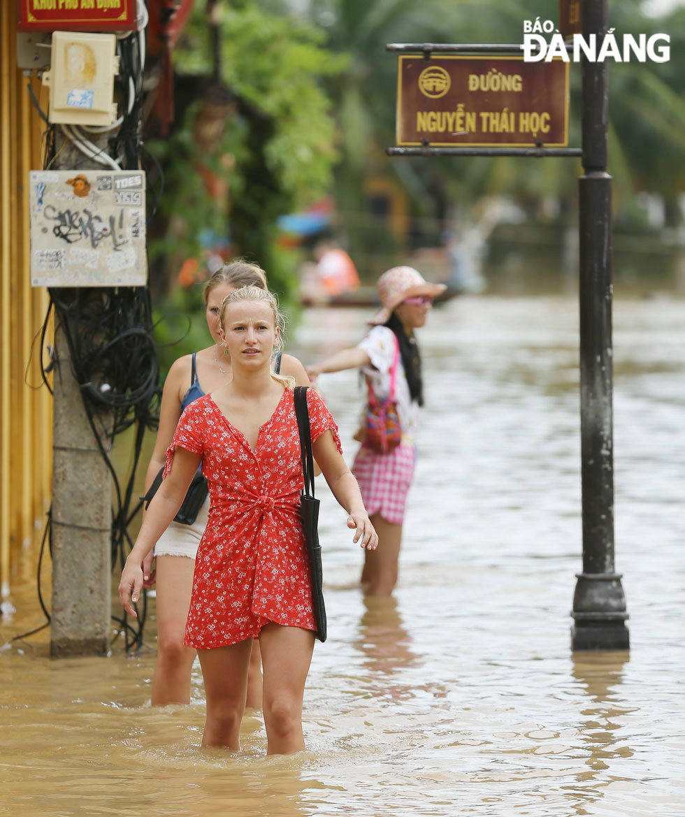 Nhiều du khách lần đầu thấy đường phố Hội An ngập lụt nên thích thú lội nước.