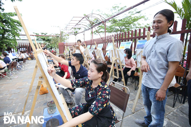 Artist Huynh Cong Thanh (right) gives guidance to young participants in a recent painting experience programme at Art For Arch. Photo: D.H.L