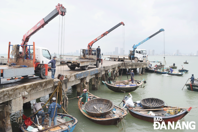 Fishermen are seen urgently pulling small boats ashore to avoid recent typhoon Noru  Photo: HOANG HIEP