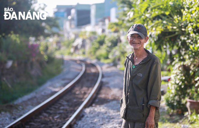 Mr. Dang Van Loi works as a volunteer railway guard at the railway line running through residential areas. Photo: KHUONG MY