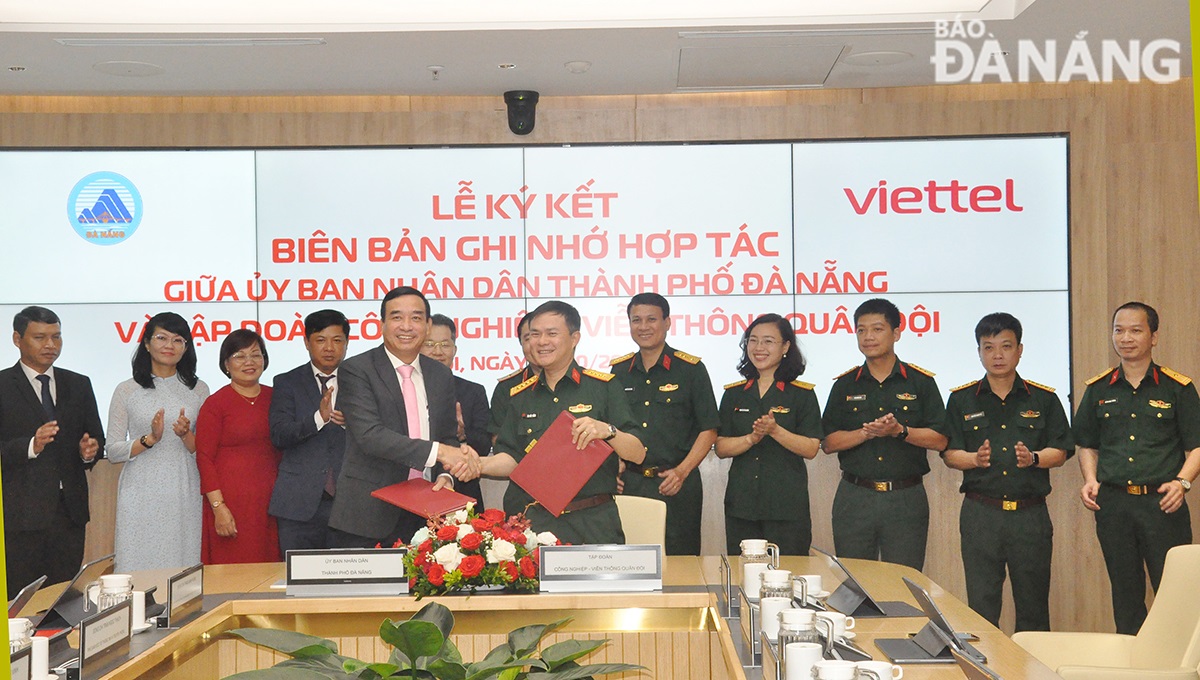 Da Nang People's Committee Chairman Le Trung Chinh (left in front row) and Chairman and General Director of Viettel Group Colonel Cao Duc Thang (right in front row) shaking hands to congratulate the cooperation signing event.