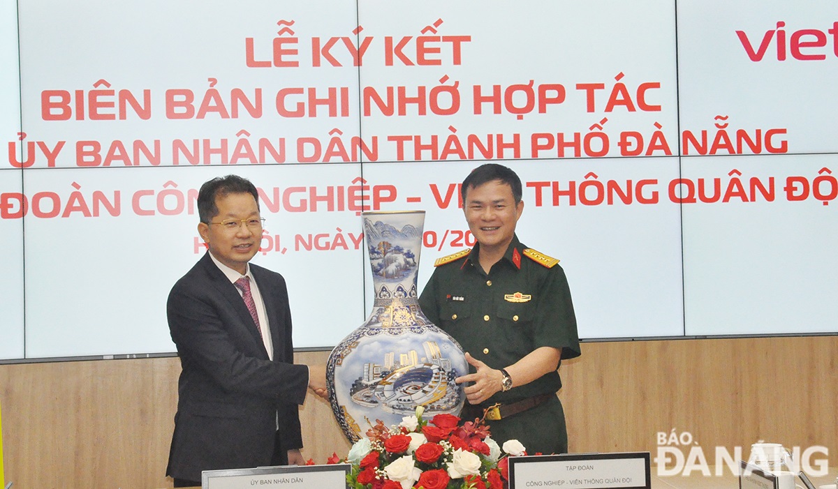 Da Nang Party Committee Secretary Nguyen Van Quang receives a souvenir from the leader of Viettel Group