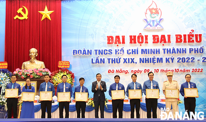 Chairman of the Da Nang People's Committee Le Trung Chinh (centre) awarding Certificates of Merit from the municipal People's Committee to 10 outstanding collectives in recognition of their active involvement in the city's youth movements last term. Photo: XUAN DUNG