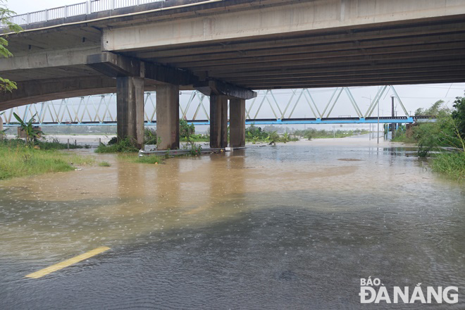 The Cam Le River has overflowed its banks after heavy downpours, causing deep water move into a low-lying section of Thang Long Street.