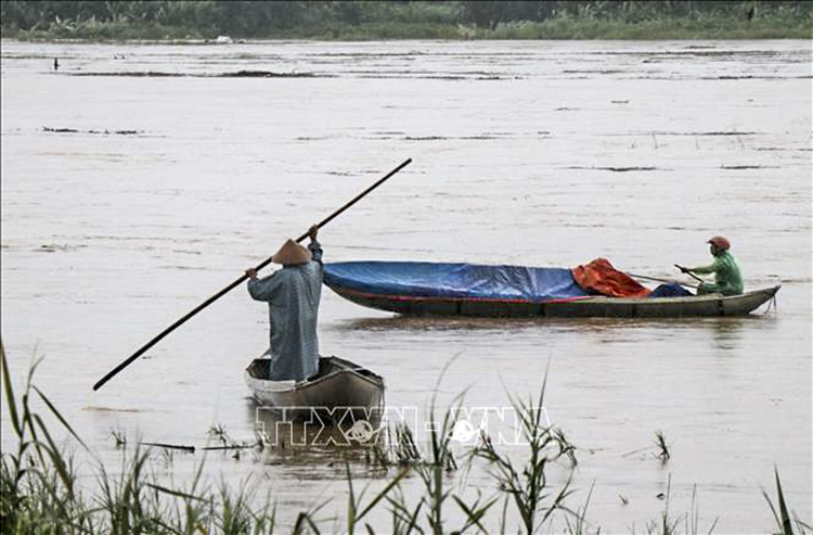 Nước lũ sông Trà Khúc qua thành phố Quảng Ngãi (tỉnh Quảng Ngãi) dâng cao người dân di chuyển bằng ghe nhỏ trên sông. Ảnh: Phạm Cường-TTXVN