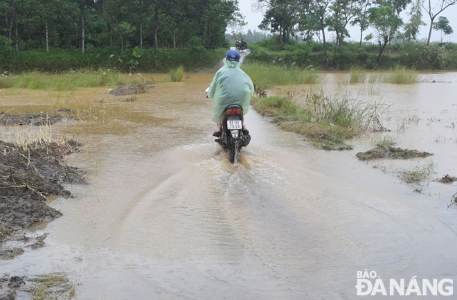 The Yen River has overflowed its banks, sending a large amount of water to flood nearby low-lying roads. Photo: HOANG HIEP