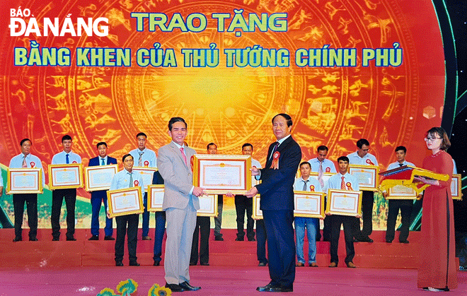 Phó Thủ tướng Chính phủ Lê Văn Thành (bên phải, hàng trên cùng) trao bằng khen của Thủ tướng Chính phủ cho ông Bùi Cam, xã Hòa Ninh, huyện Hòa Vang về thành tích xuất sắc trong phong trào nông dân sản xuất kinh doanh giỏi giai đoạn 2017 - 2022. Ảnh: VĂN HOÀNG	