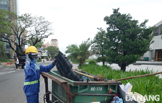 Công nhân Công ty CP Môi trường đô thị Đà Nẵng thu gom rác, vệ sinh trên tuyến đường Bạch Đằng