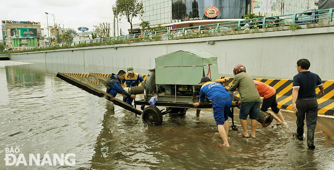 Lực lượng chức năng xử lý nươc ngập hầm chui phía tây cầu Trần Thị Lý. Ảnh: THÀNH LÂN