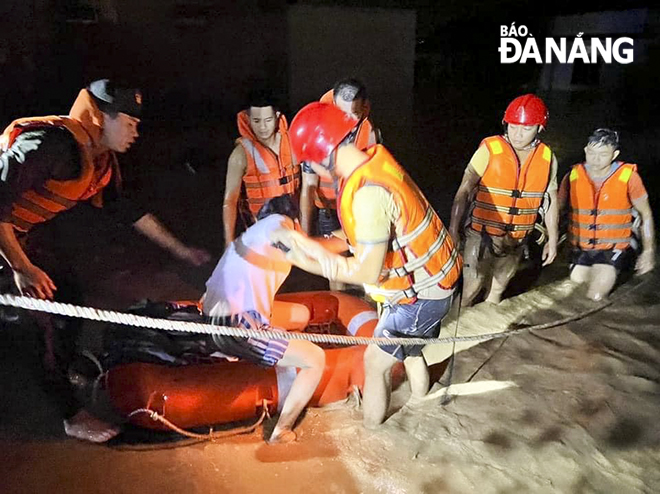 The military personnel helping stranded people reach a safe place in the night.